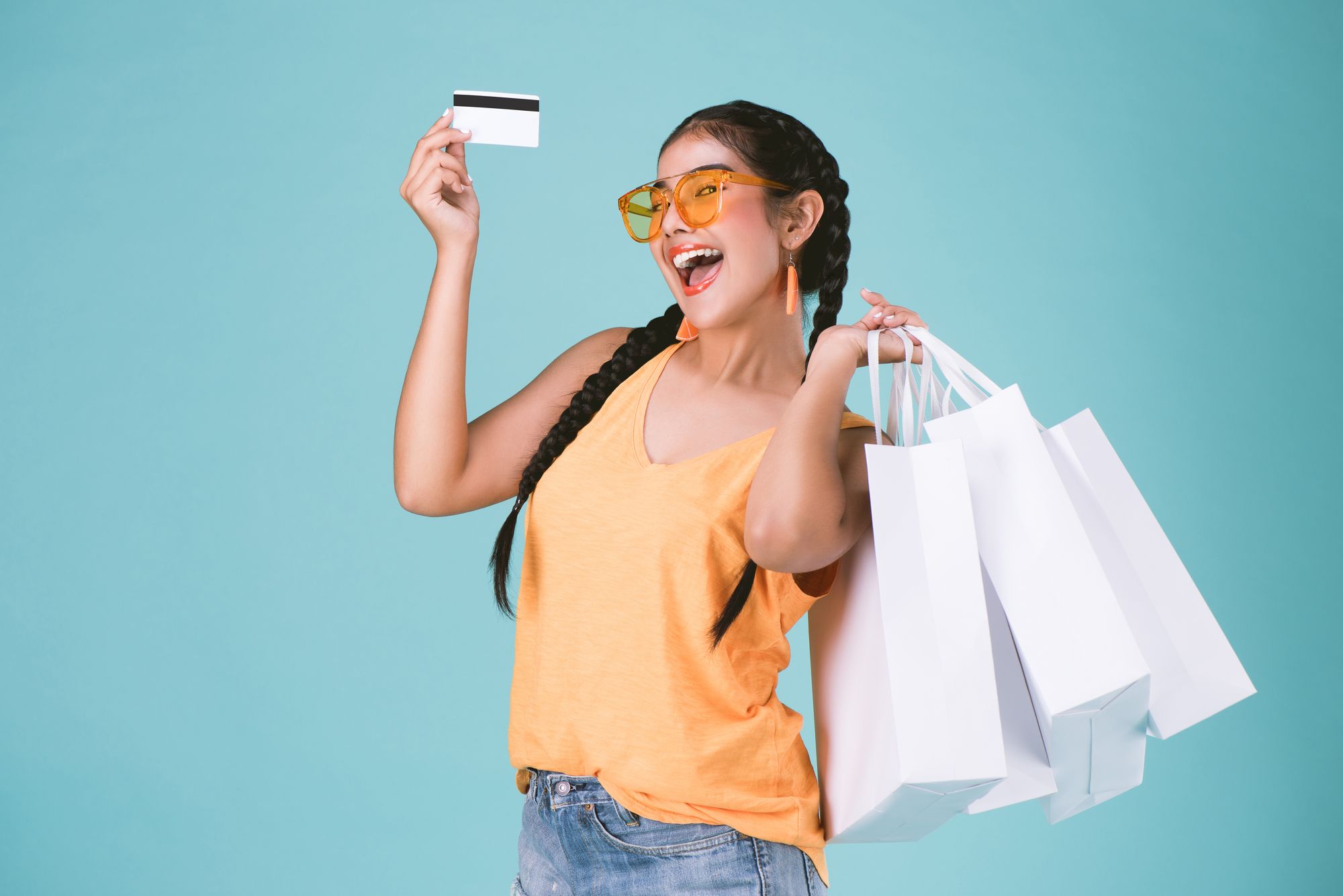 ショッピングバックとカードを持ち喜ぶ女性