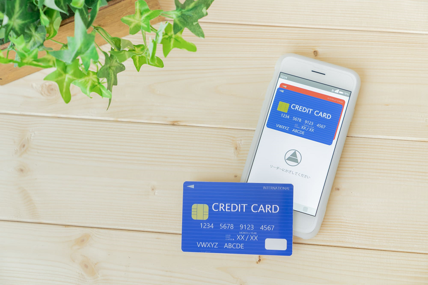 青いクレジットカードとそのカードの画面が表示されたスマホ